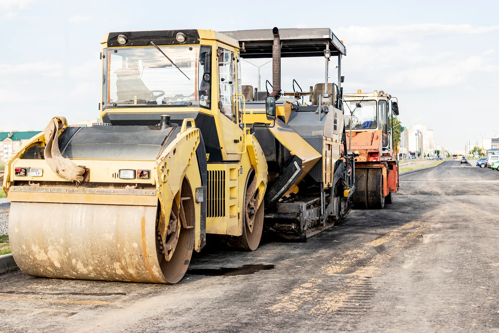 Paver dan roller menurap lapisan asfalt baharu di jalan raya / Paver and rollers laying a fresh asphalt course on a highway